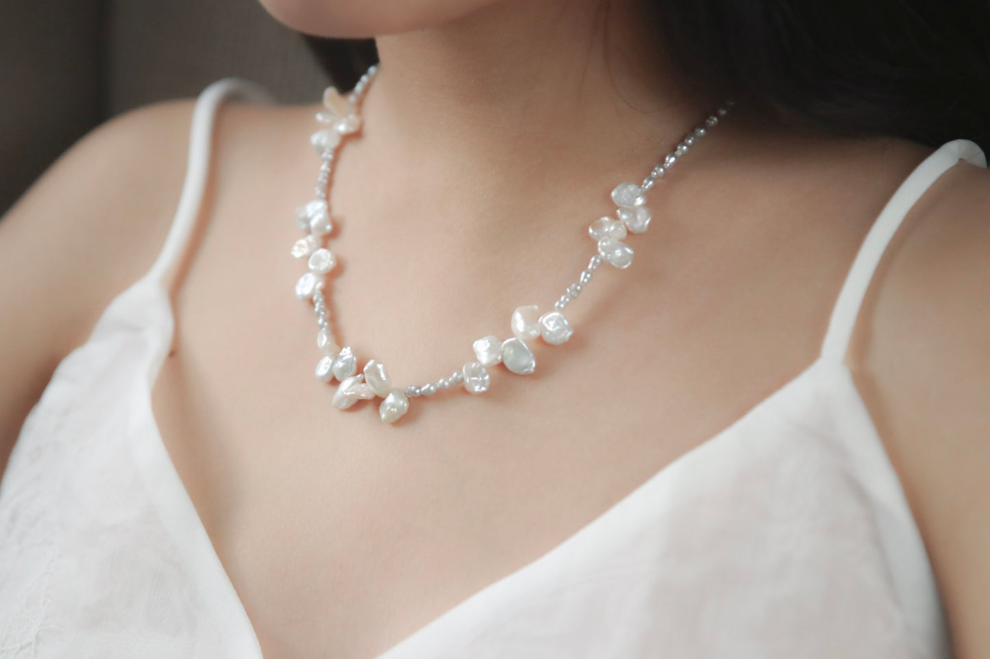 Diese unvergleichlich schöne Kette besteht aus grauen Keshiperlen und weißen Barockperlen – wie eine Blüte aus dem Meer