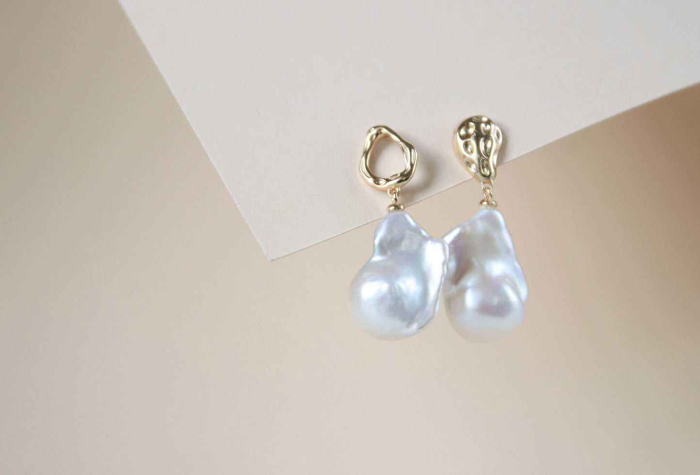 Asymmetrische Ohrstecker und schimmernden barocken Perlen in Regenbogenfarben – elegante, einzigartige Schmuckstücke, ideal für festliche Anlässe.