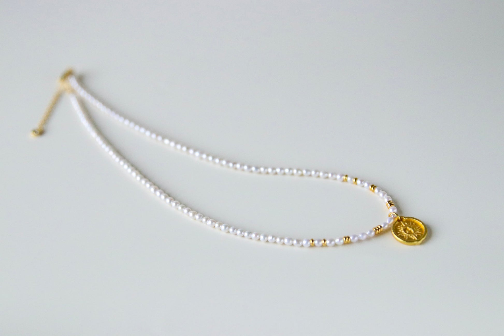 Halskette aus Süßwasserperlen und goldenem Münzanhänger / Necklace made of freshwater pearls with a golden coin pendant