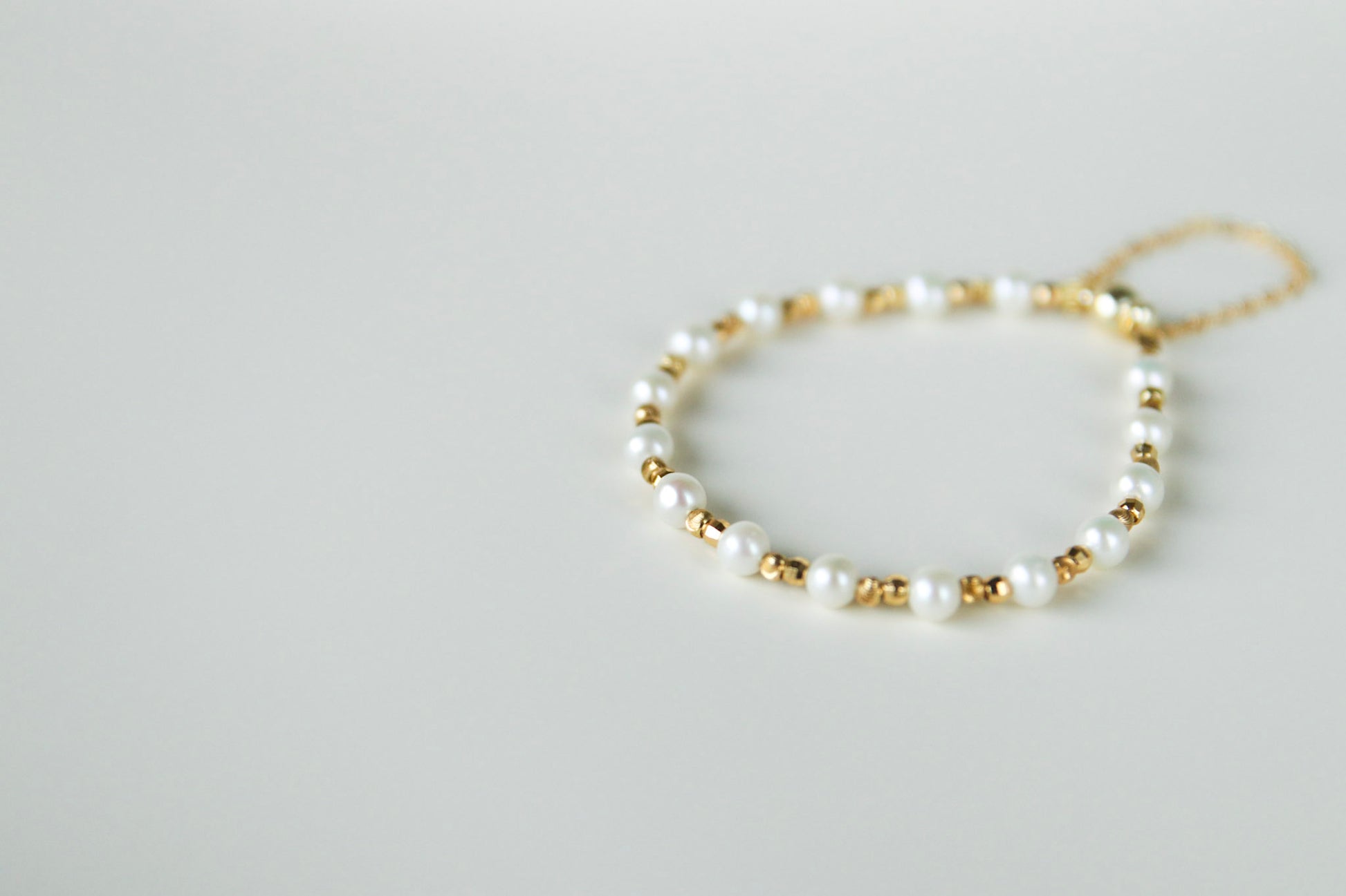 Perlenarmband aus Süßwasserperlen mit vergoldeten Metallkügelchen / Pearl bracelet with gold-plated metal beads
