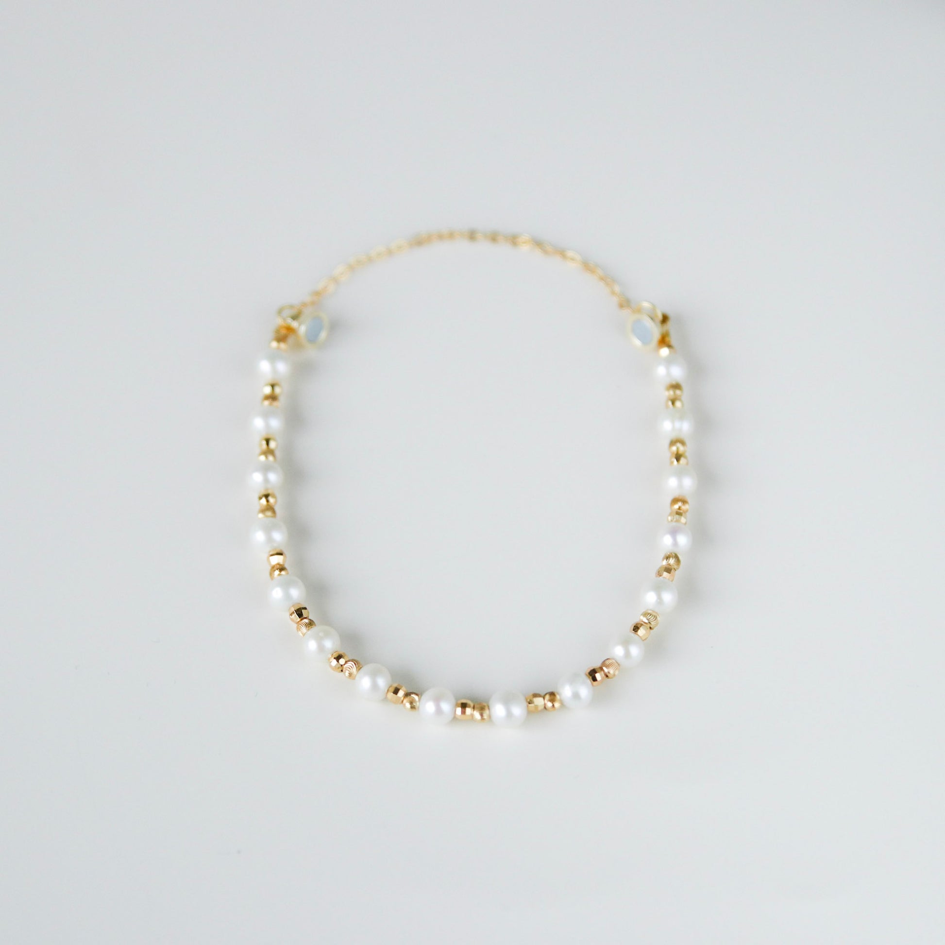 Perlenarmband aus Süßwasserperlen mit vergoldeten Metallkügelchen
